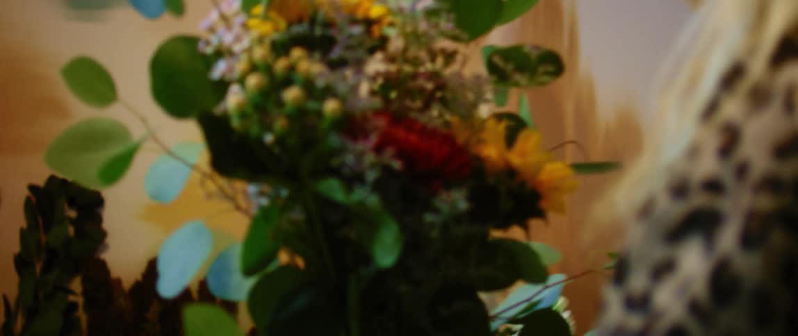 Blonde woman assembles a floral arrangement