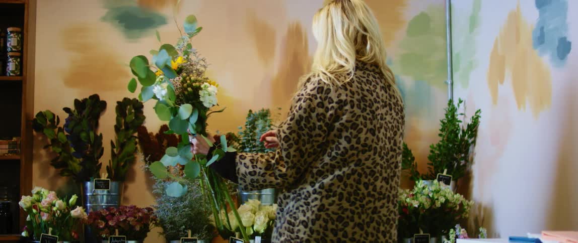 A female caucasian arranging flowers in a store
