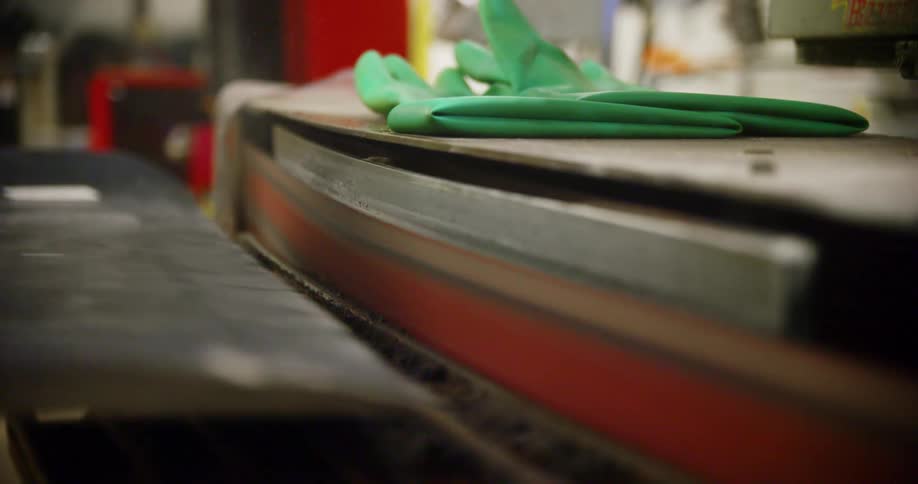 A worker grinds a piece of metal on the machine