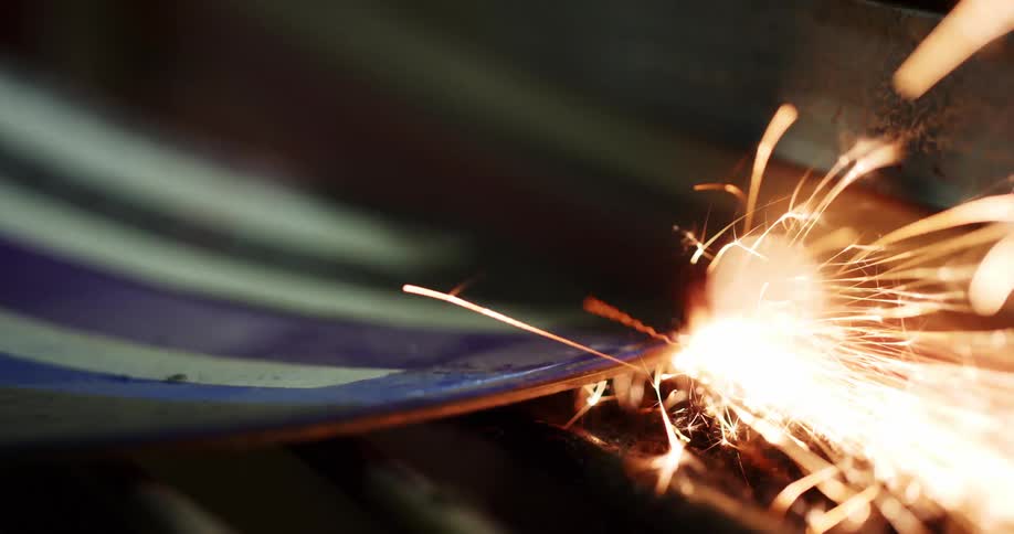 A piece of metal getting welded and sparking flames
