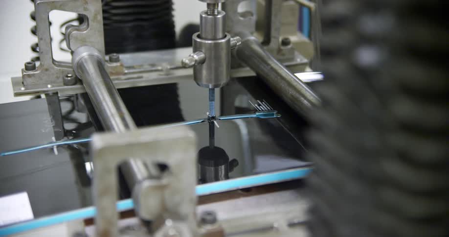 A metal machine with many parts cutting a material