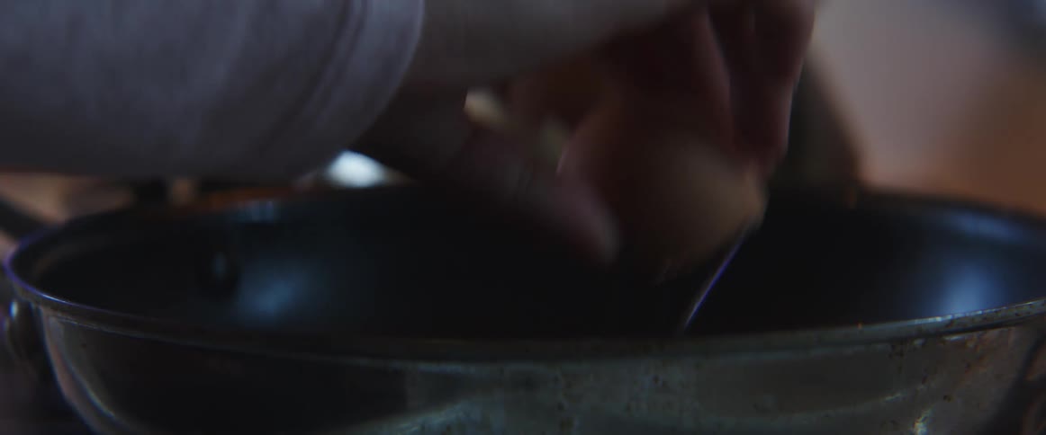 Person breaks egg into skillet