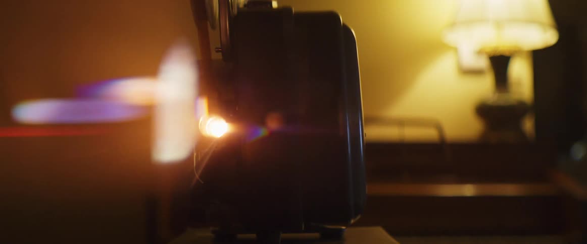 Film projector light shines brightly in dimly lit room