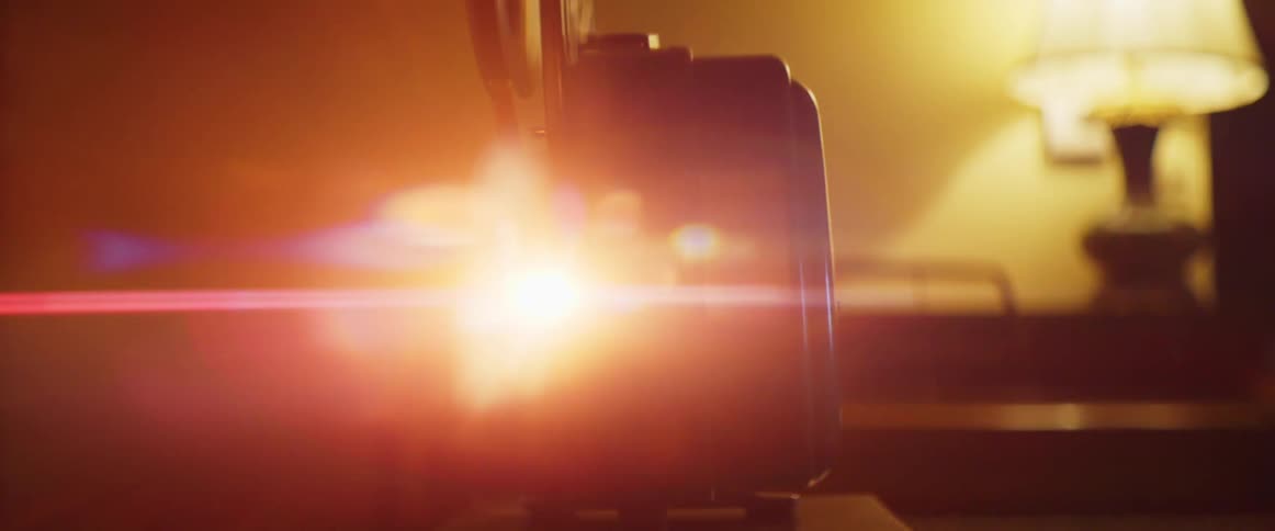 Light shines from a movie projector in a dark room