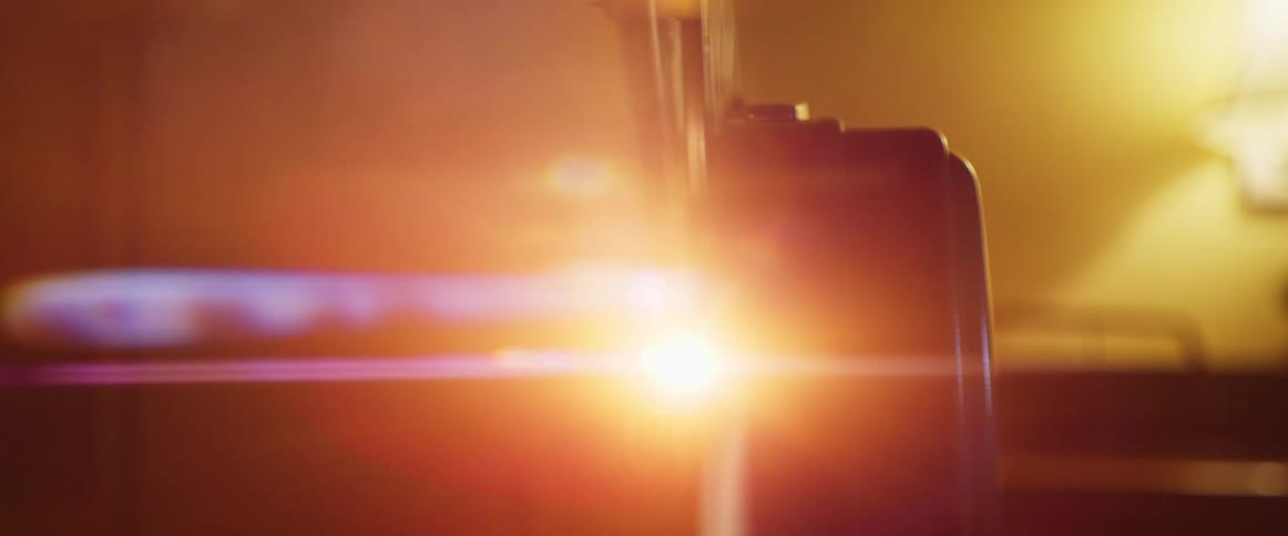 Bright lights come on as a film projector starts playing in a movie theater