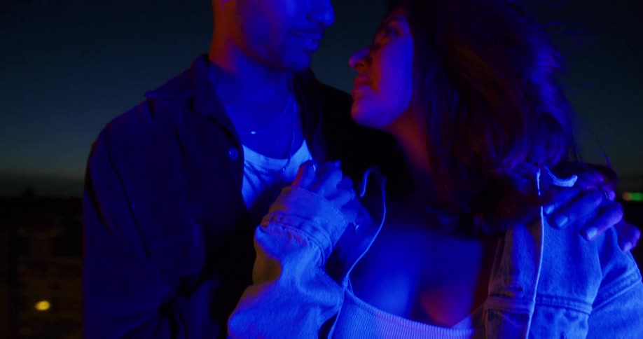 A couple are hugging outside on a windy night