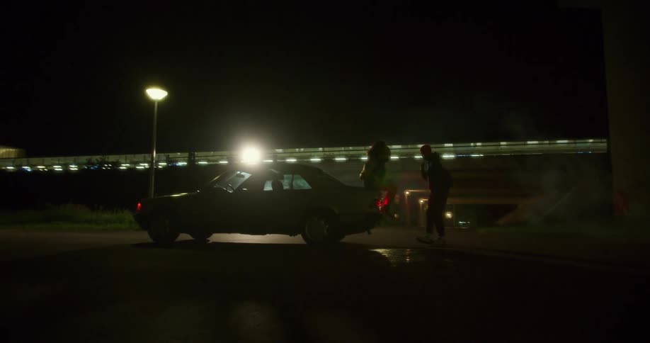 A couple play around in the parking lot