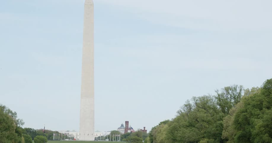 People walk around pond near washington monument