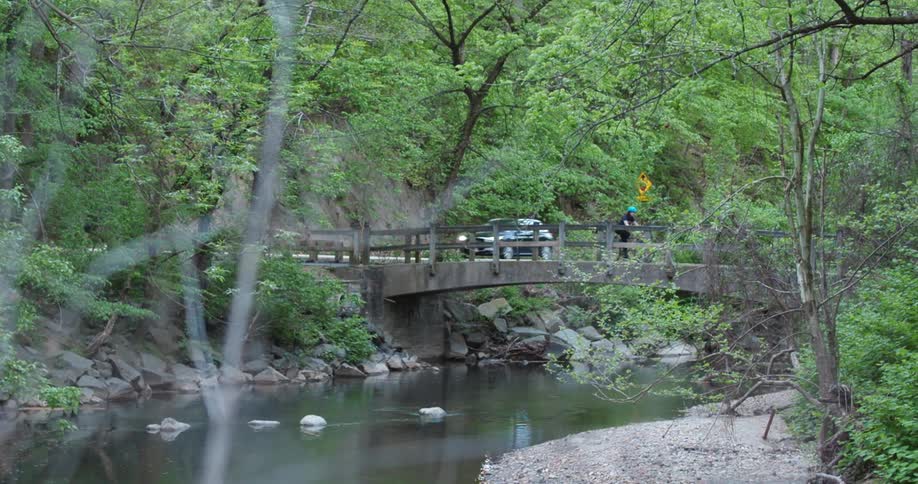 A person rides their bike over the bridge