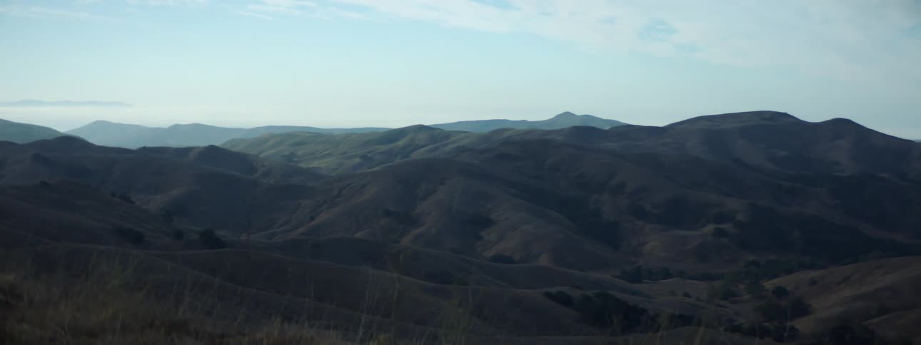 A hilly countryside under a clear sky during the day
