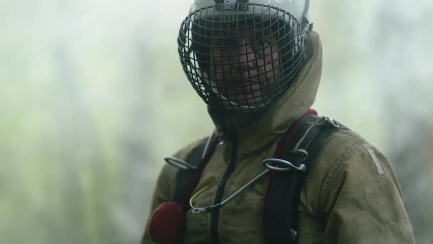 A man standing outside with a helmet on that protects his face
