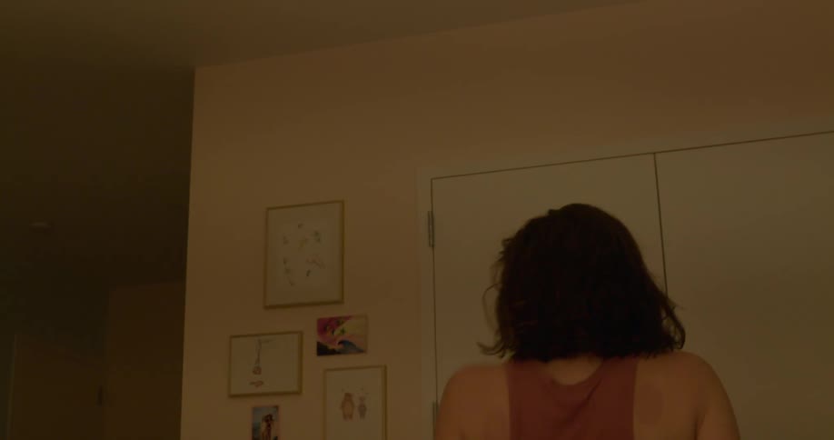 A woman uses a hairbrush as a microphone as she sings and dances in her apartment