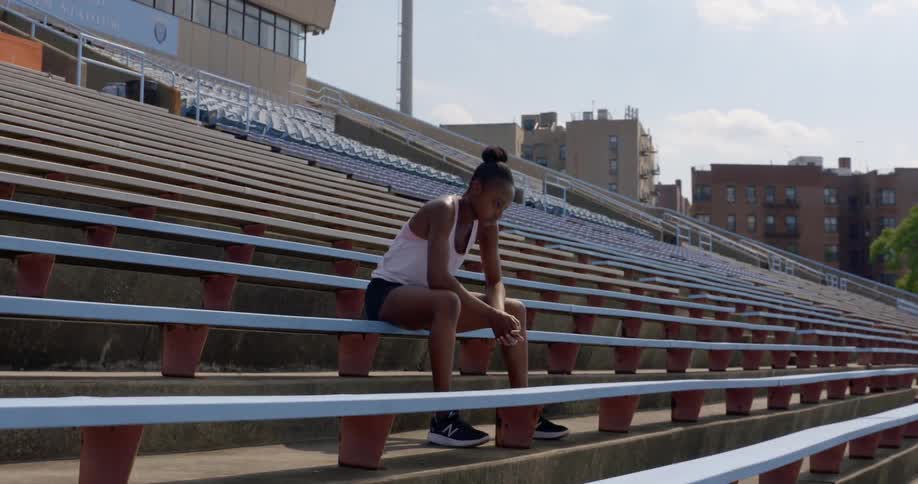 Woman sits in stadium alone thinking