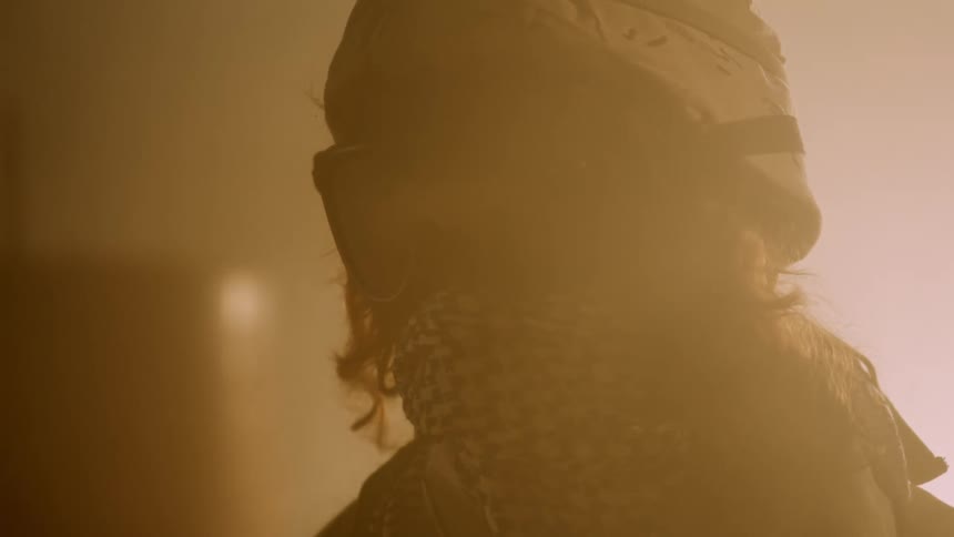 Person in helmet goggles and gaiter stands in heavy yellow mist