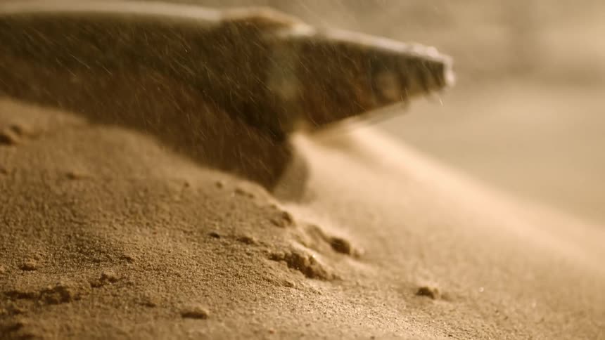Unknown tool half buried on a small sand dune