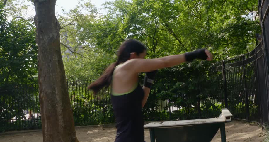 A woman is boxing outdoors in spring