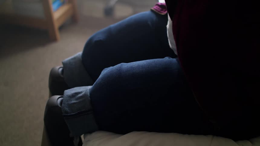 A woman with prosthetic legs sits at home