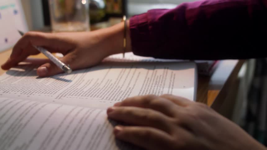 A woman in an office reads through paperwork