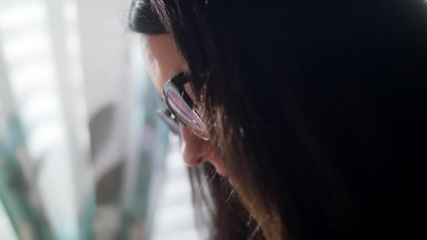 Side view of a woman with glasses and black hair