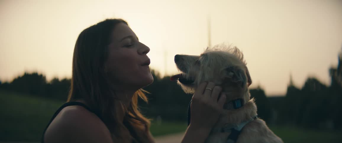 A female caucasian petting a dog outside