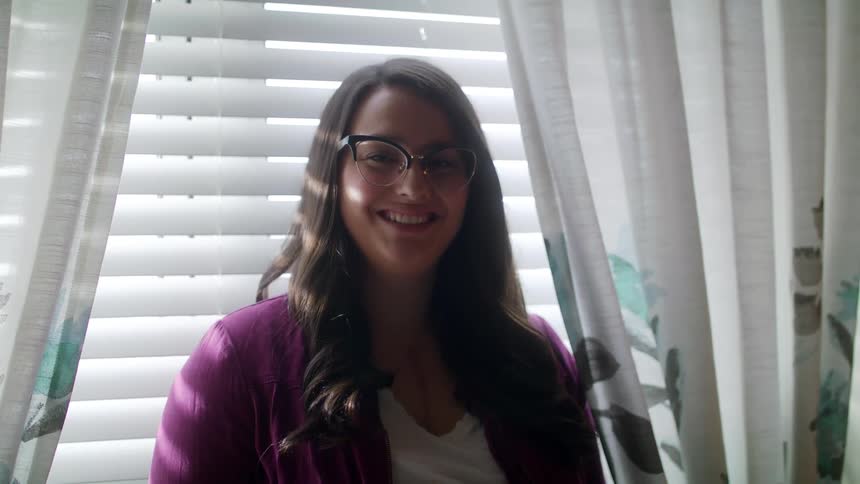 A woman is smiling inside a house