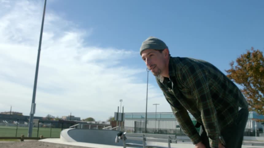 A man walks over and drops a skateboard