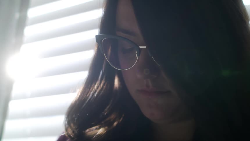 A woman in her home looking down as she thinks