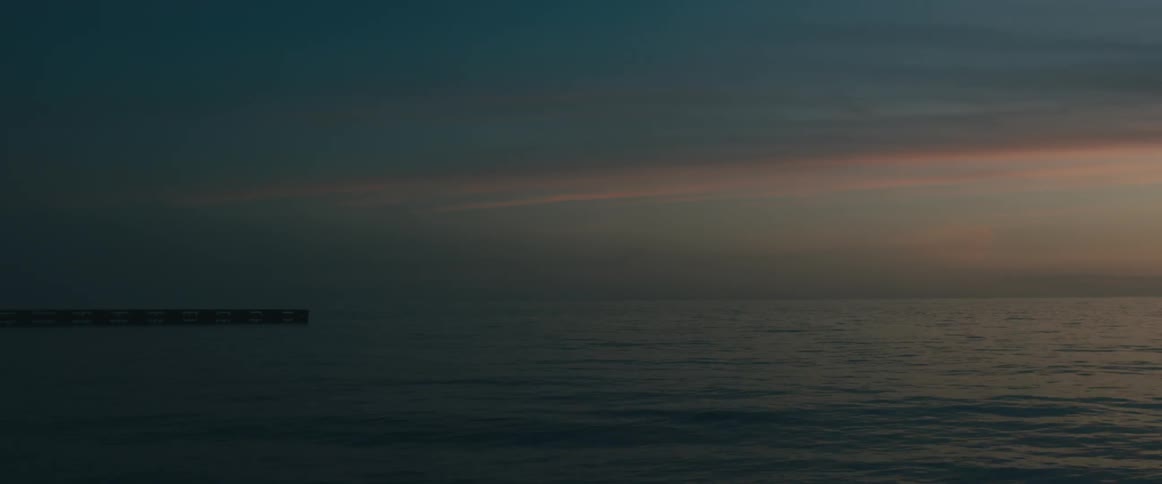 Small pier over the calm ocean waters at sunset