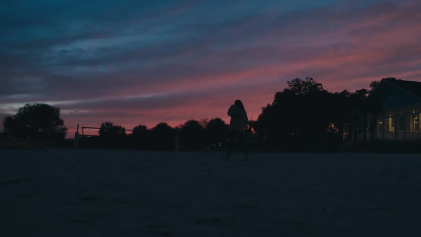 A person walking on a beach at night