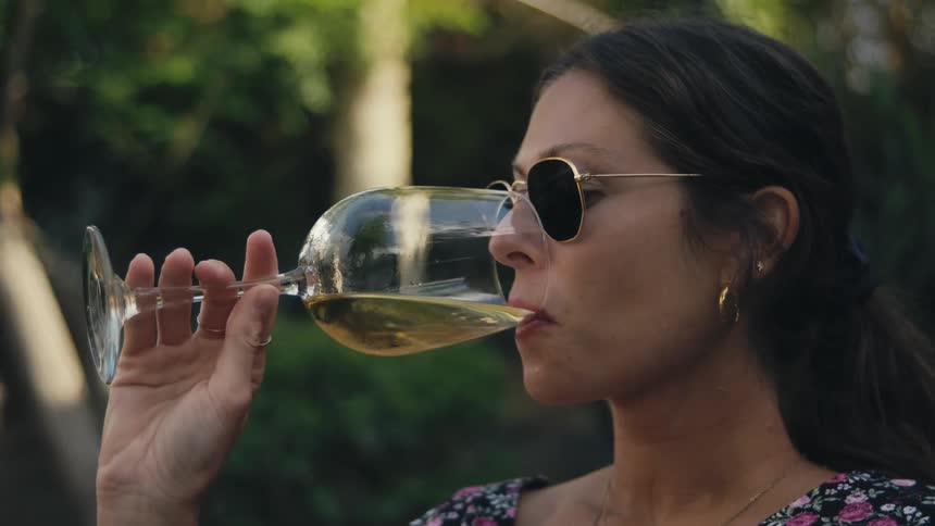 A woman is drinking wine outdoors in spring