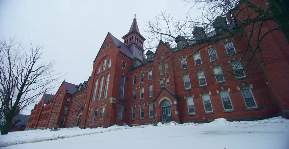 A large building with a red brick facade under a clear sky on a winter day