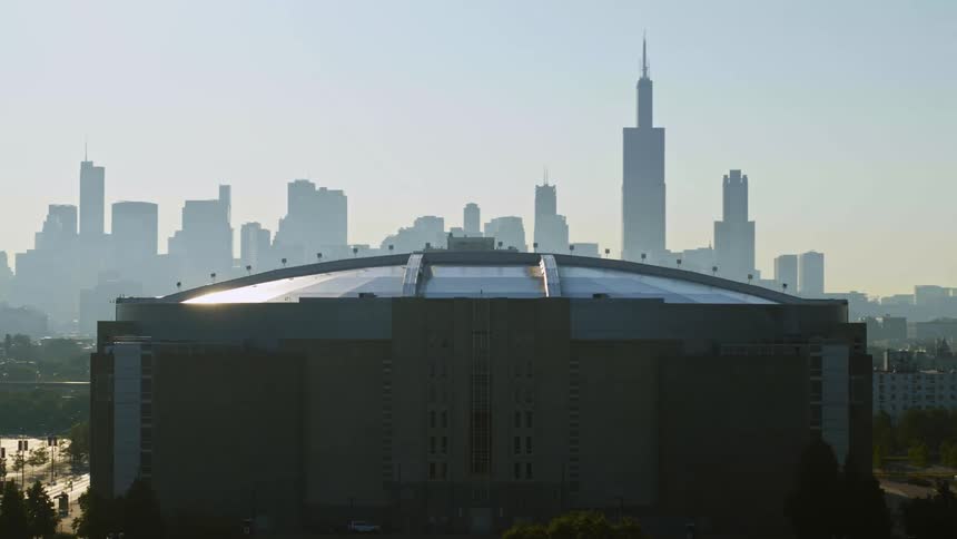 United Center surrounded by trees and streets with Chicago skyline in background