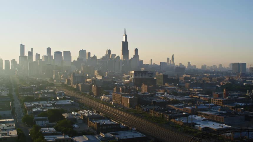 Empty highway runs between buildings toward fog covered Chicago skyline