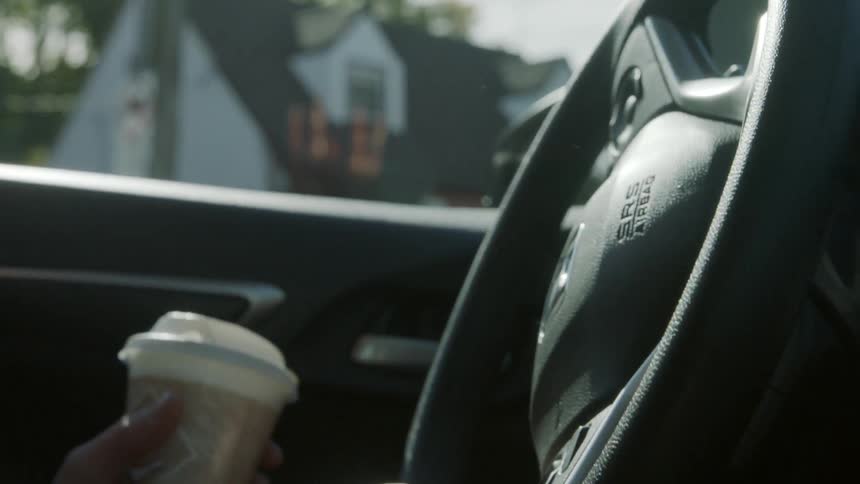 A person is driving a car on a sunny day