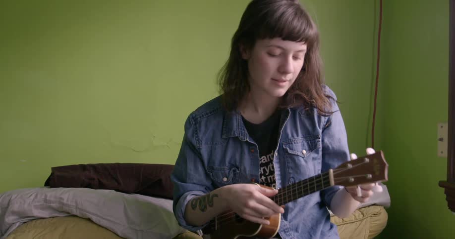 A woman tunes a guitar