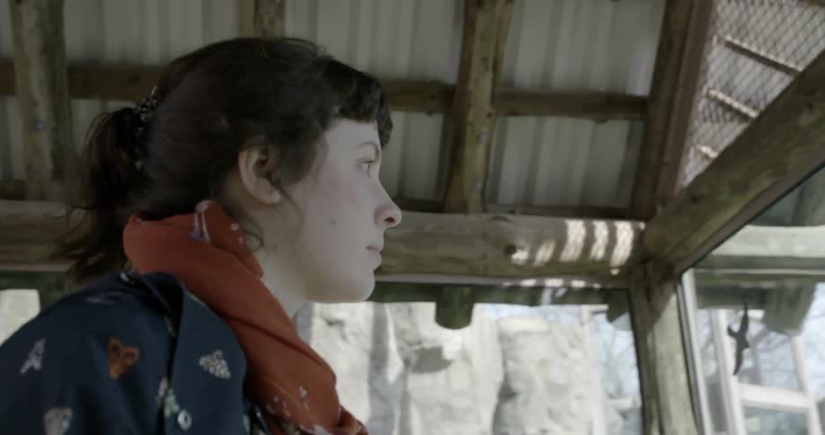 A woman in a red scarf looks around