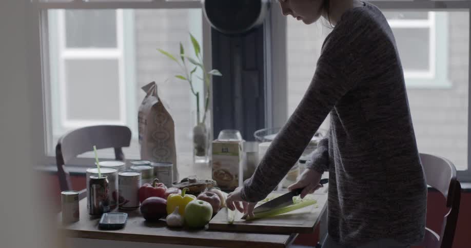 A woman is cutting food on a table