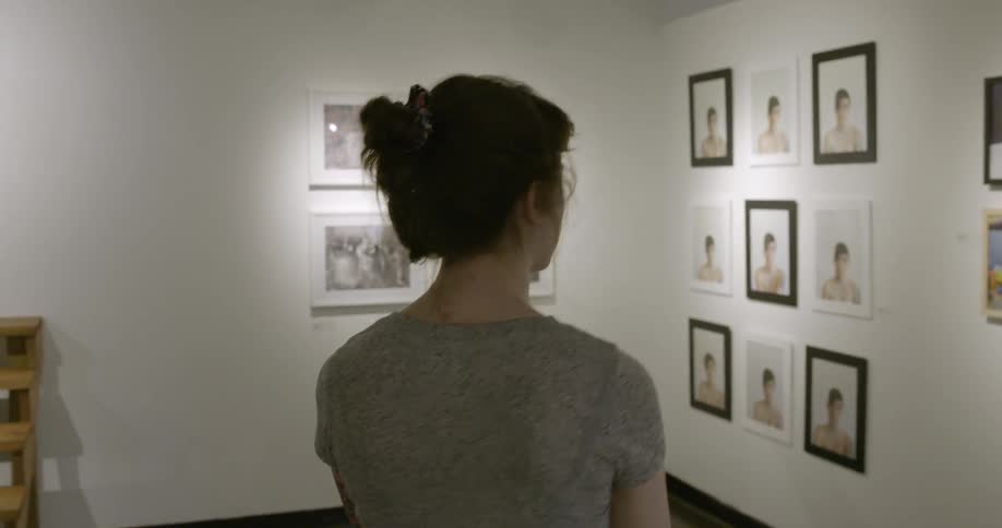A woman walks through an art exhibit