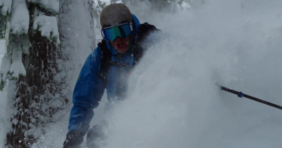 A skier speeds over powdery snow on a winter day