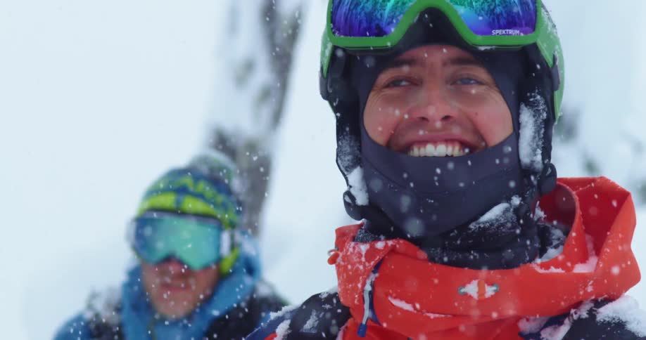 Two skiers smile in the heavy snowfall