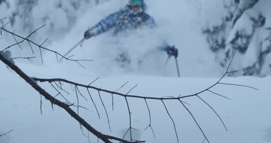 Man skis through extremely deep powder in the background beautiful