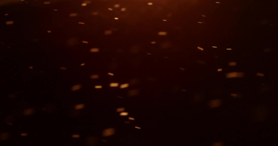 Snow particles flow through the night in the wind