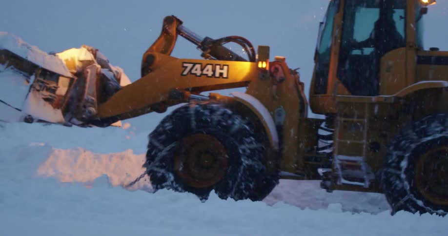 Yellow snow plows push snow during a snow storm