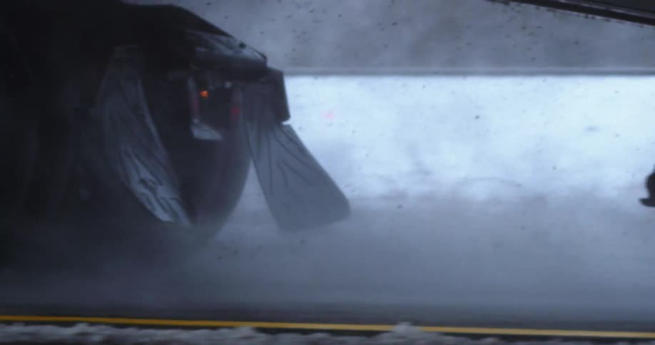 Truck driving on the wet tarmac on a snowy road