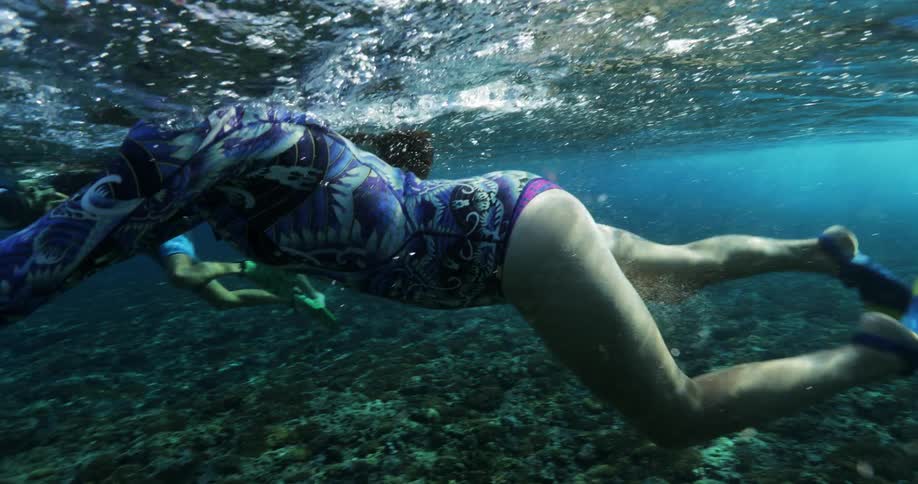 Women swimming underwater in the ocean