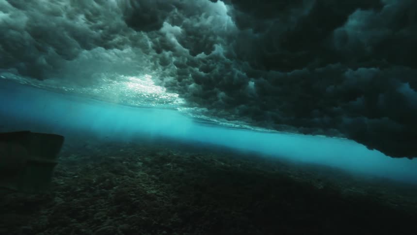 Underwater view of waves creating underwater clouds of turbulence