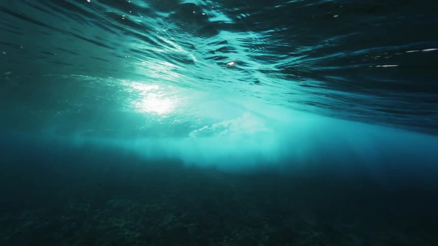Underwater footage of a wave running on the surface over a swimmer