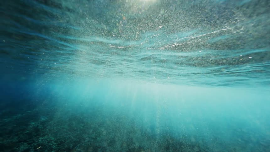 Underwater footage of sunlight filtering from the surface of the calm blue ocean waters
