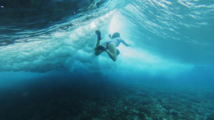 A wave rolls over a woman in the ocean