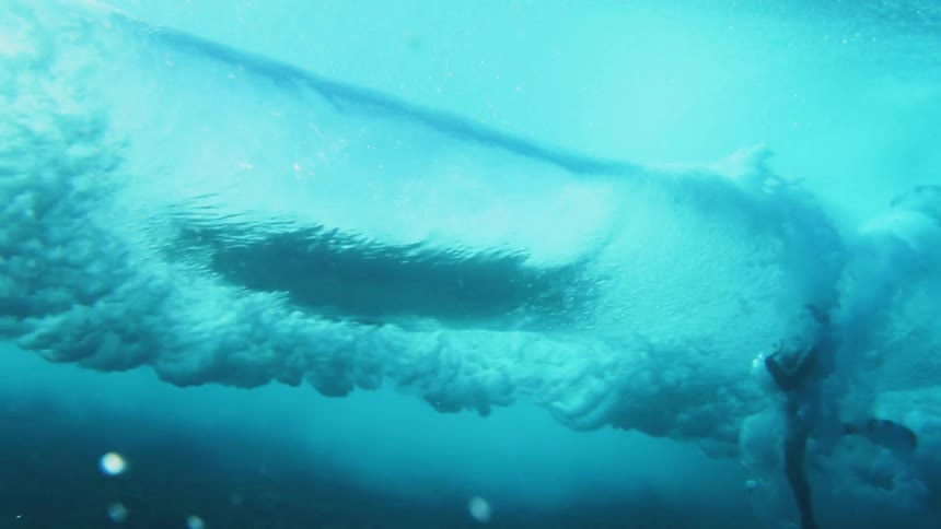 Underwater view of a surfer falling on a wave